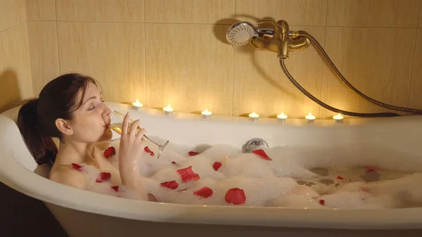 Piękna Kobieta Bierze Kąpiel Przy Świecach Pije Szampana — Zdjęcie stockowe