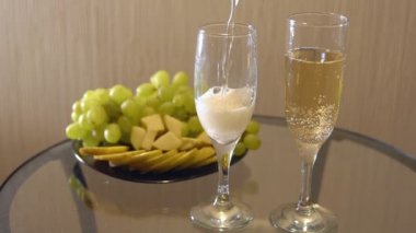 Şampanya bardakları ve meyve masaya bir tabak