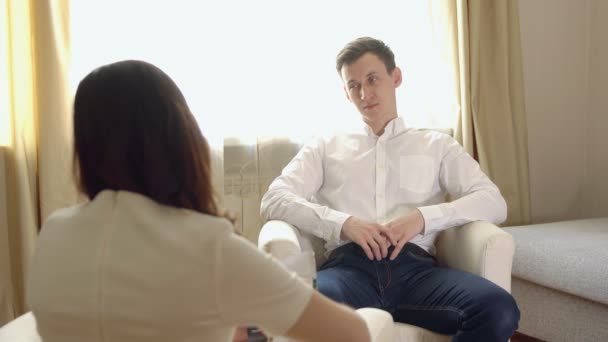 Молодой человек на приеме с женщиной-психологом — стоковое видео