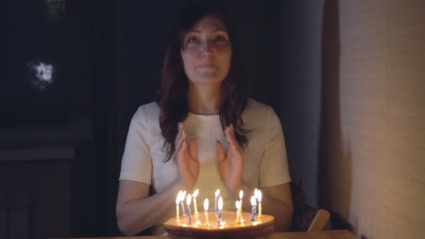 Beautiful woman blowing out candles on a festive cake — Stock Video