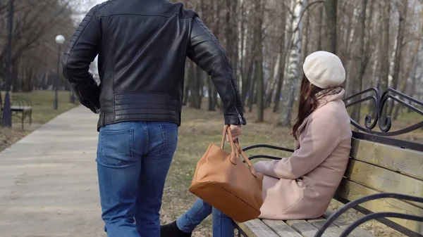 若い男は公園のベンチから女性のバッグを盗み — ストック写真