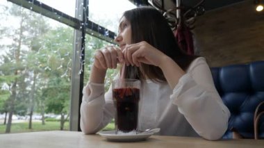 Genç kadın bir kafede mulled şarap içme.