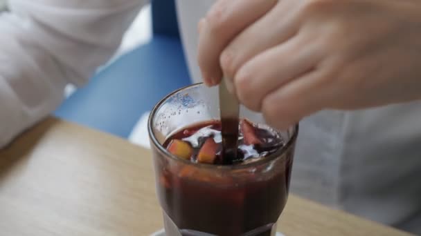 Женщина в кафе перемешивает глинтвейн — стоковое видео