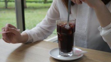 Genç kadın bir kafede mulled şarap kıpırdanırken