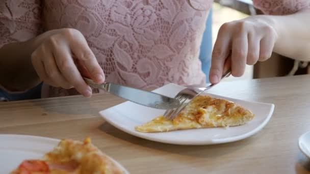 Brünette Frau in einem Café isst eine leckere Pizza — Stockvideo