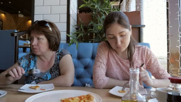 Vrouw en een meisje ondervindt diner in een café, pizza eten — Stockvideo