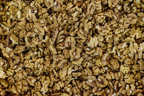 Pieces of chopped walnut as an abstract background texture.