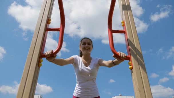 Koncepcja fitness, sport, trening, park i styl życia. nastolatek szczęśliwy uśmiechający się i robi pompki na ławce na zewnątrz — Wideo stockowe