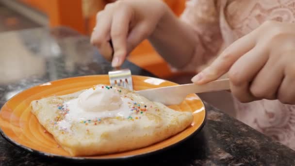 Mädchen isst Pfannkuchen mit Eis im Café — Stockvideo