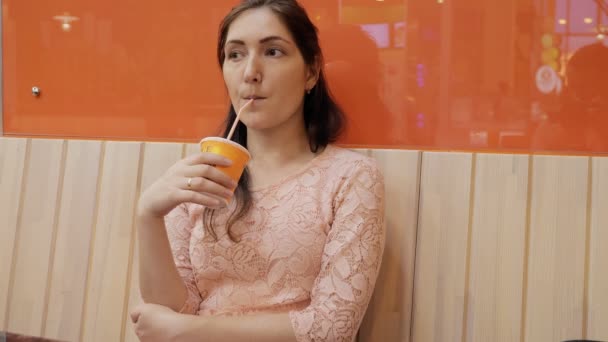 Cafe-asszony ivás lé eszik egy belsejében, kávéházban — Stock videók