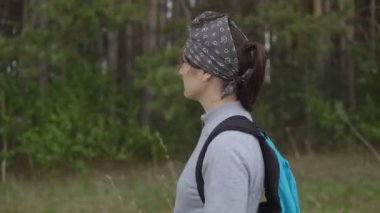 Orman gülümseyen üzerinden yürüyen sırt çantası olan esmer kadın