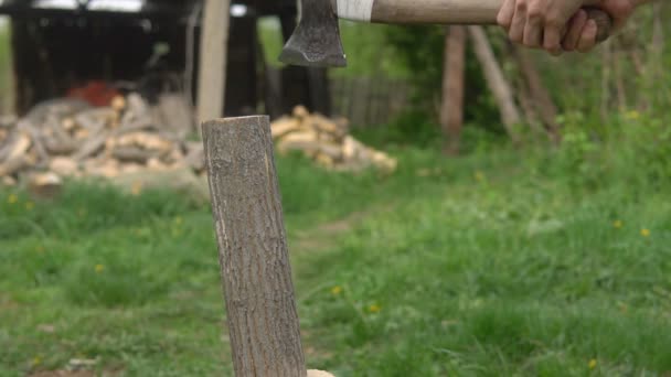 Mann hackt Holz im Hof. Rohlinge für den Winter — Stockvideo