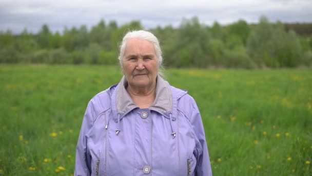 Vuxen kvinna med grått hår på naturen leende — Stockvideo