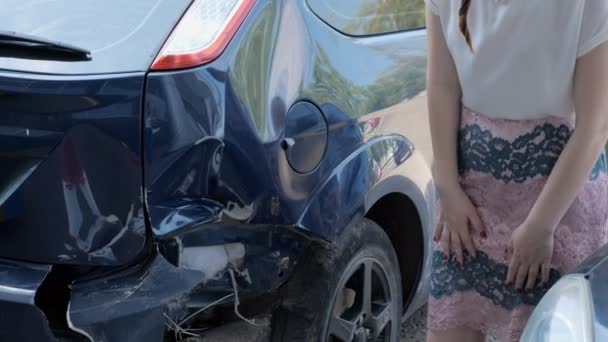 Frustrated brunette woman is standing near a broken car — Stock Video