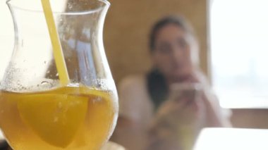 Cam cam bir kokteyl ve saman genç bir kadın arka plan üzerinde