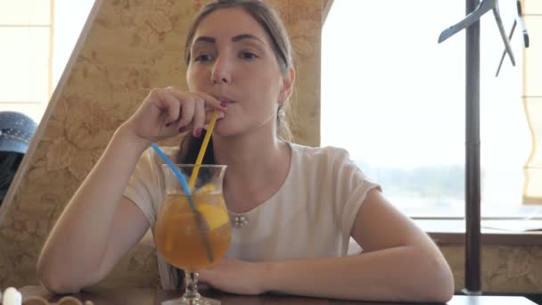 Schöne Frau in einem Café trinkt einen Cocktail — Stockvideo