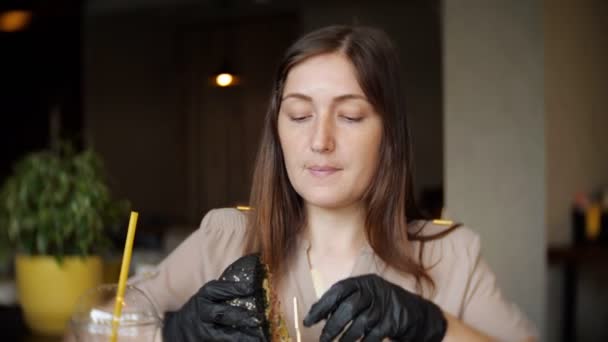 Mujer comiendo hamburguesa de pollo de comida rápida en el restaurante — Vídeos de Stock