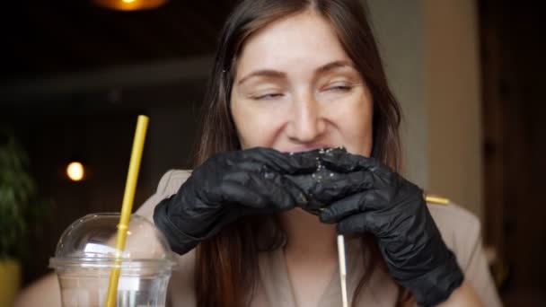 Mujer comiendo hamburguesa de pollo de comida rápida en el restaurante — Vídeo de stock