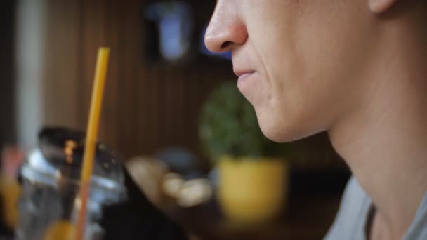 Hungry young of man in black gloves eating a burger in a cafe, slow motion — Stock Video