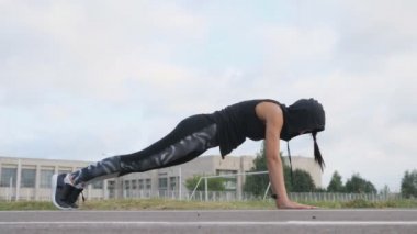 Stadyum üzerinde tahta egzersiz yaparak fitness genç kadın atlet