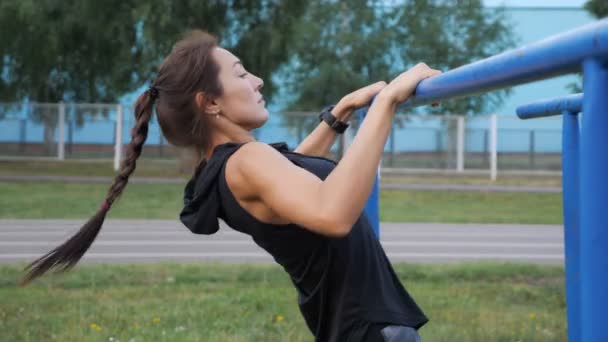 Spor giyim sportif genç kadın çekti çubuğu'nda açık havada — Stok video