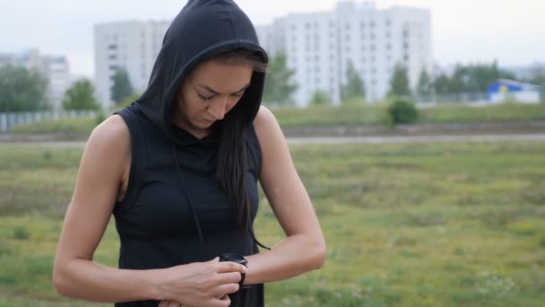 Kadın fitness smartwatch çalıştırmak için ayarlama. Sporcumuz kontrol saati aygıt — Stok video