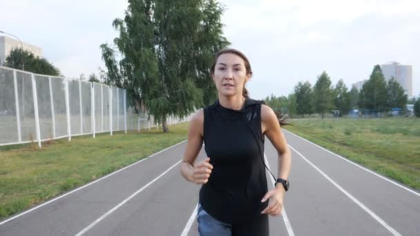 Cámara lenta de la chica corriendo en el estadio al aire libre — Vídeos de Stock