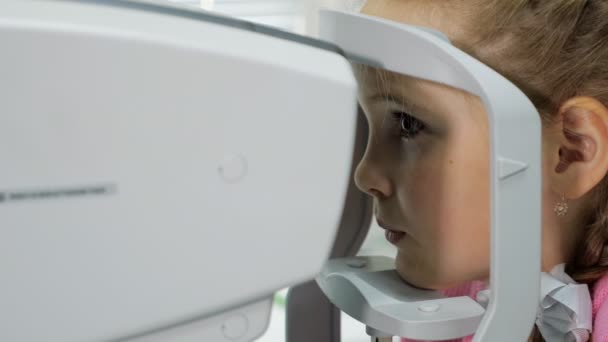 Optometrista examina la vista de la niña — Vídeos de Stock