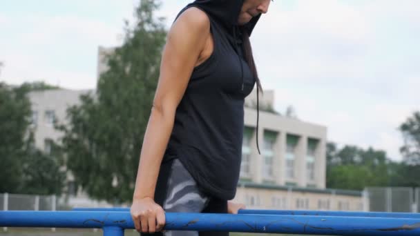 Спортивная девушка делает трицепс упражнения на балках — стоковое видео