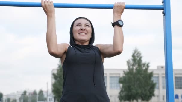 Sportowy młoda brunetka Kobieta w sportowej wyciągnął na pasku w siłownię na świeżym powietrzu — Wideo stockowe