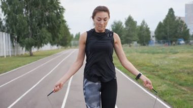 fitness, spor, eğitim, park ve yaşam tarzı konsepti - kadın atlama halatıyla dışarıda egzersiz yapıyor