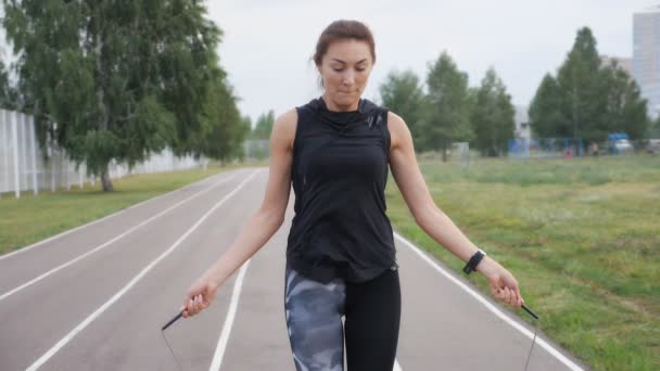 Fitnesz, sport, edzés, park és életmód koncepció - ugrókötéllel a szabadban gyakorló nő — Stock videók