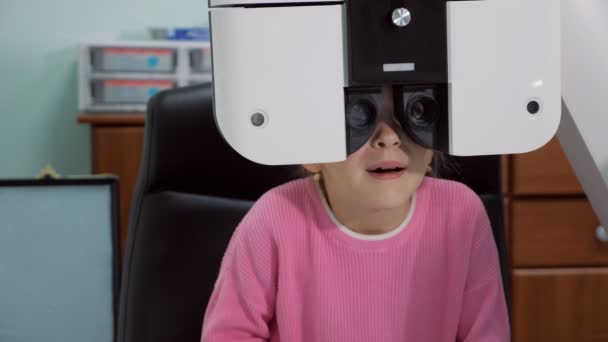 Primer plano de una niña una prueba de ojos en antes del nuevo año escolar — Vídeos de Stock