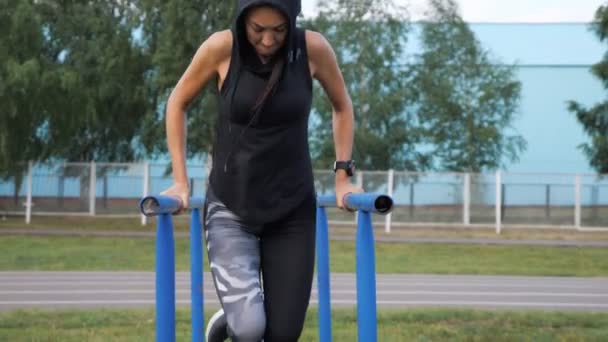 Sportliches Mädchen macht Trizepsübung auf dem Balken — Stockvideo