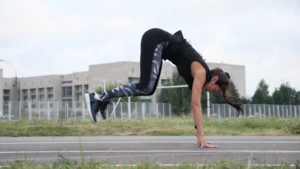 Schönes Mädchen macht Crossfit-Übungen, springt und klatscht — Stockvideo