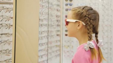 Alışveriş merkezinde ekranından güneş gözlüğü seçtiğiniz sevimli küçük kız