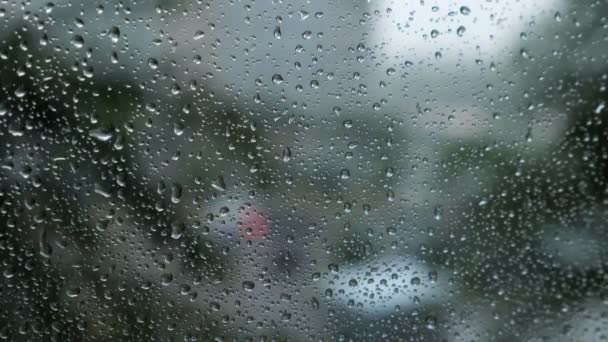 Vista traffico offuscata attraverso un parabrezza auto coperto di pioggia per lo sfondo — Video Stock
