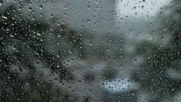 在雨中覆盖的汽车挡风玻璃模糊的交通视图背景 — 图库视频影像