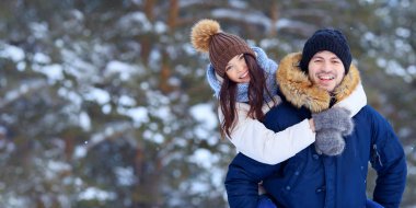 Karlı kış ormanda yürüyüş oynak genç bir çift. Arka plan, boşaltmak bulanıklık