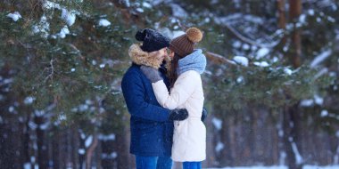 Mutlu genç çift karlı kış ormanda sarılmak. Erkek ve kadın aşık romantik yaşam tarzı
