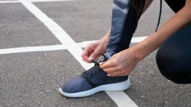 Kız runner dantel bir parkta yolda onu ayakkabı koşu için bağlama. Spor yaşam tarzı.