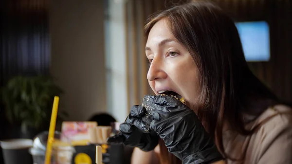 Side View Young Girl Black Gloves Eating Burger Cafe — Stock Photo, Image