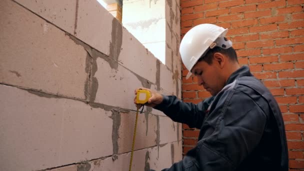 L'uomo misura la lunghezza della finestra nell'edificio — Video Stock