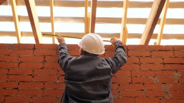 Builder pomiaru drewniane belki w budynku — Wideo stockowe