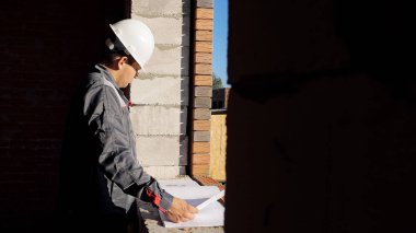 Adam pencerede evde kağıt taslak seyir yapım aşamasında işçisi ayakta yan görünüm