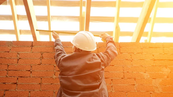 Bauunternehmer misst Holzbalken im Gebäude — Stockfoto