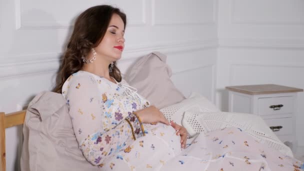 Όμορφη έγκυος γυναίκα αγκαλιά στο κρεβάτι — Αρχείο Βίντεο
