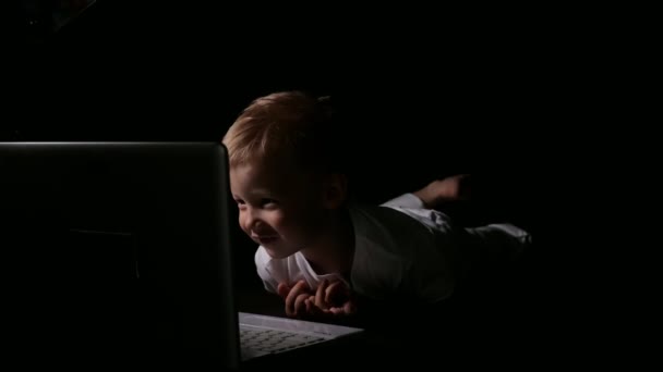 Pequeño niño viendo portátil en la oscuridad — Vídeos de Stock