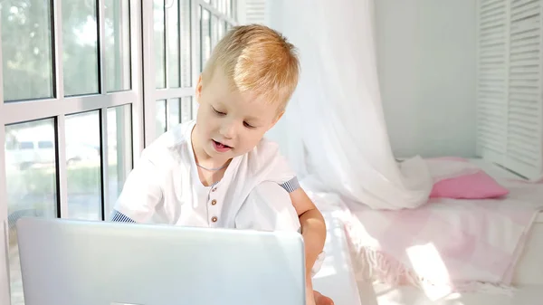 Schattig Jongetje Zittend Vensterbank Van Grote Witte Venster Laptop — Stockfoto