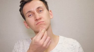 Onun yüzünde acnes arayan genç adam portresi